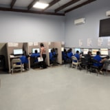 Students learning at computers in a Juárez classroom with support